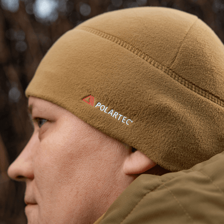 Henkilö pukeutuneena M-Tac Fleece Watch Cap Light Polartec hiekansävyisessä fleecessä, sopii talvikäyttöön, valmistettu Polartec Micro Series -materiaalista.