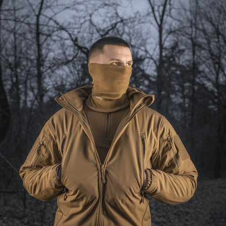 Mies metsässä käyttäen M-Tac Tube Scarf Polartec -tuubia, täydellinen ulkoiluun ja kylmään säähän.