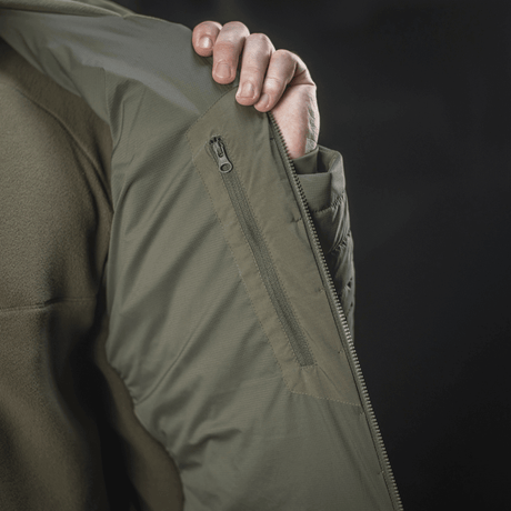 Yksityiskohta M-Tac Jarl -takista, näkyvissä hengittävä Toray stretch -nylon ja vetoketjutasku; sopii välikaudelle ja suojaksi kylmältä.