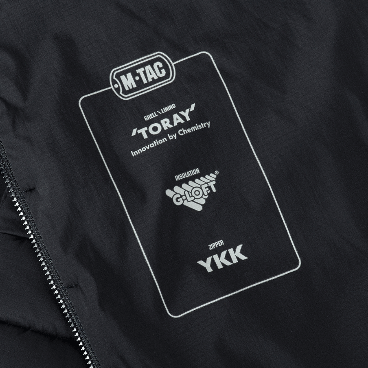Yksityiskohta M-Tac Jarl -takista Toray-, G-Loft- ja YKK-merkinnöillä.