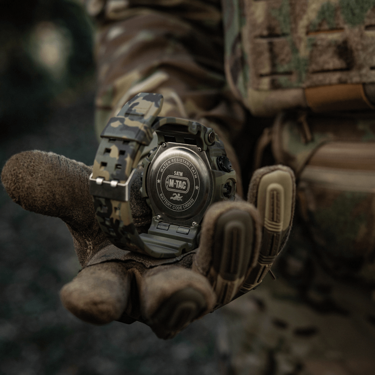 M-Tac Tactical Ur 2037 camokuvioitu, 5atm, pidetty taktisen hanskan kädessä metsässä en