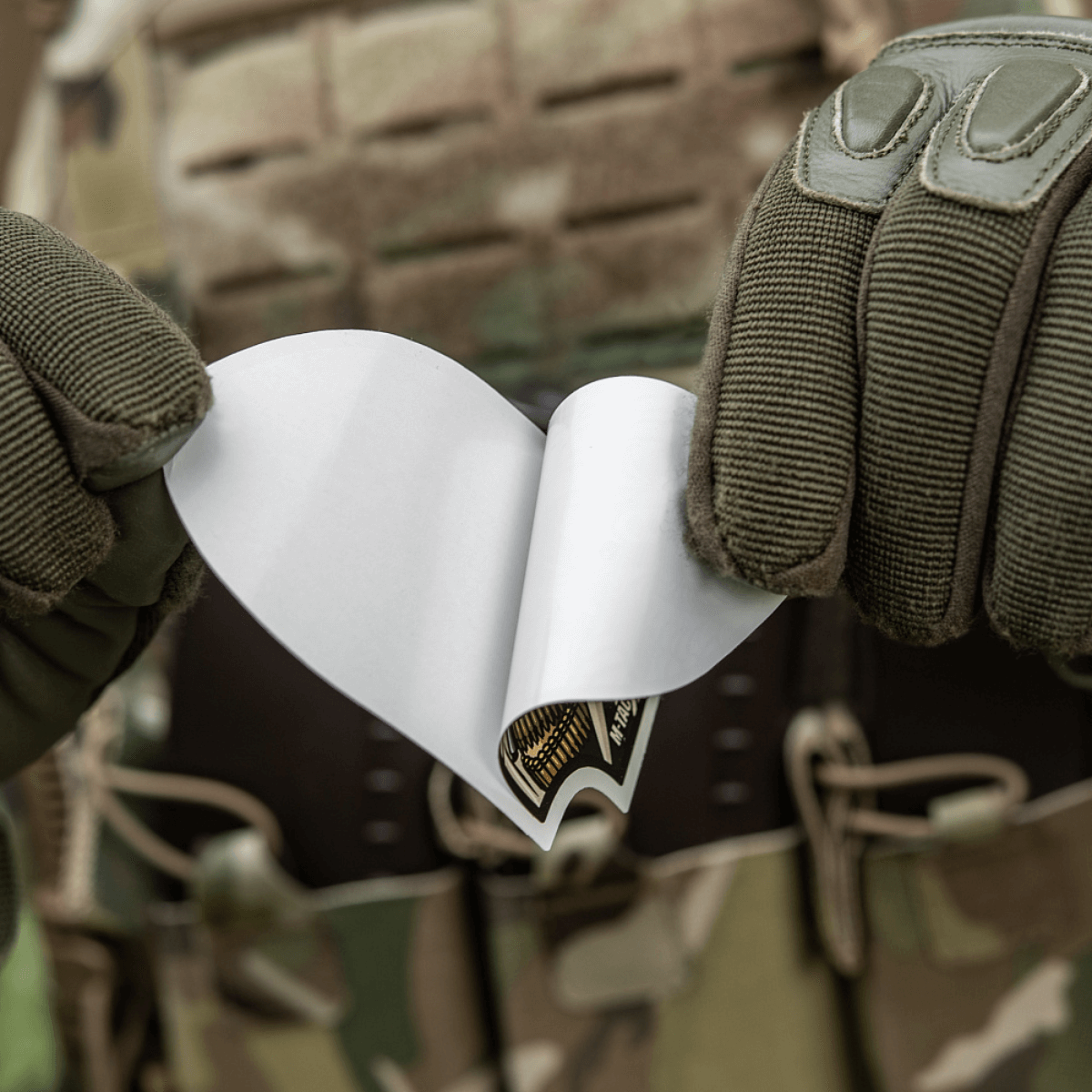 M-Tac Sticker Valkyrie maastokuvioisen henkilön kädessä, käyttövalmis; esittää päättäväisen sotajumalattaren M4-kiväärin Arrowhead-patchissä.