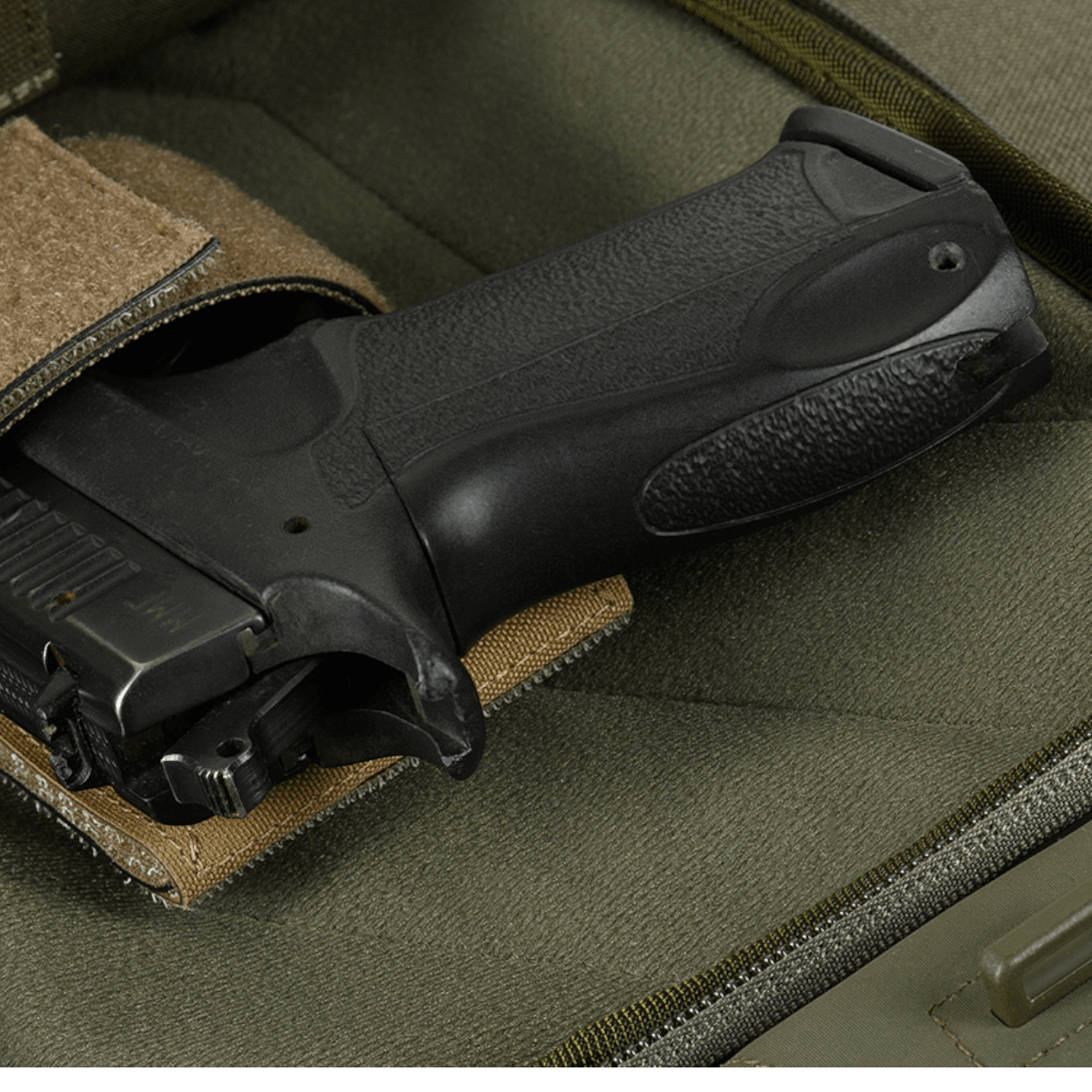 Kuva M-Tac Buckler Taske Elite Hexistä, piilotettu asekotelo ja MOLLE-järjestelmä harmaalla taustalla.