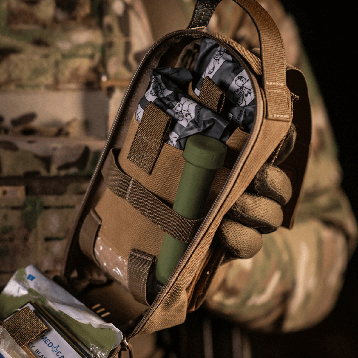 M-Tac Medical Pouch Rip Off kiinnitetty MOLLE Velcro -paneeliin, sisältää henkilökohtaisen ensiapupakkauksen, helppo repäistä irti ja ottaa mukaan.