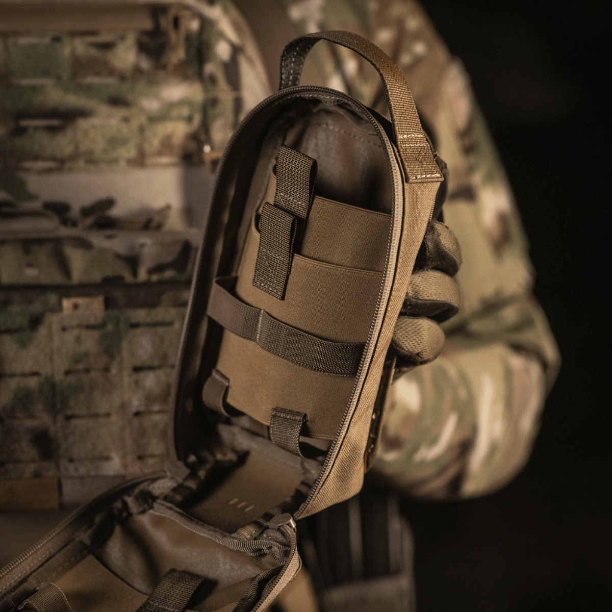 M-Tac Medical Pouch Rip Off kiinnitetty MOLLE Velcroon, auki näyttämään sisäisen säilytysmuotoilun henkilökohtaista ensiapupakkia varten.