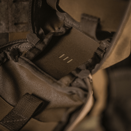 Yksityiskohtia M-Tac Medical Pouch Rip Offista vetoketjusulkimella, kiinnitettynä MOLLE Velcro -paneeleihin nopeaa pääsyä varten.