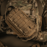 Taktinen käyttö M-Tac Medical Pouch Rip Offista kiinnitettynä MOLLE Velcro -paneeleihin, sopii nopeaan pääsyyn ensiapupakkaukseen.