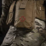 M-Tac Medical Pouch Rip Off kiinnitetty sotilaalliseen MOLLE-paneeliin, valmis nopeaan pääsyyn ensiapuvälineisiin.