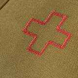 Lähikuva M-Tac Medical Pouch Rip Offista, jossa punainen ristikirjailu oliivinvihreällä taustalla, suunniteltu ensiapuun ja nopeaan käyttöön.