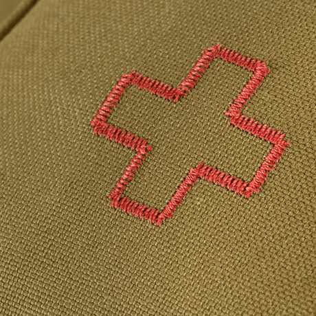 Lähikuva M-Tac Medical Pouch Rip Offista, jossa punainen ristikirjailu oliivinvihreällä taustalla, suunniteltu ensiapuun ja nopeaan käyttöön.