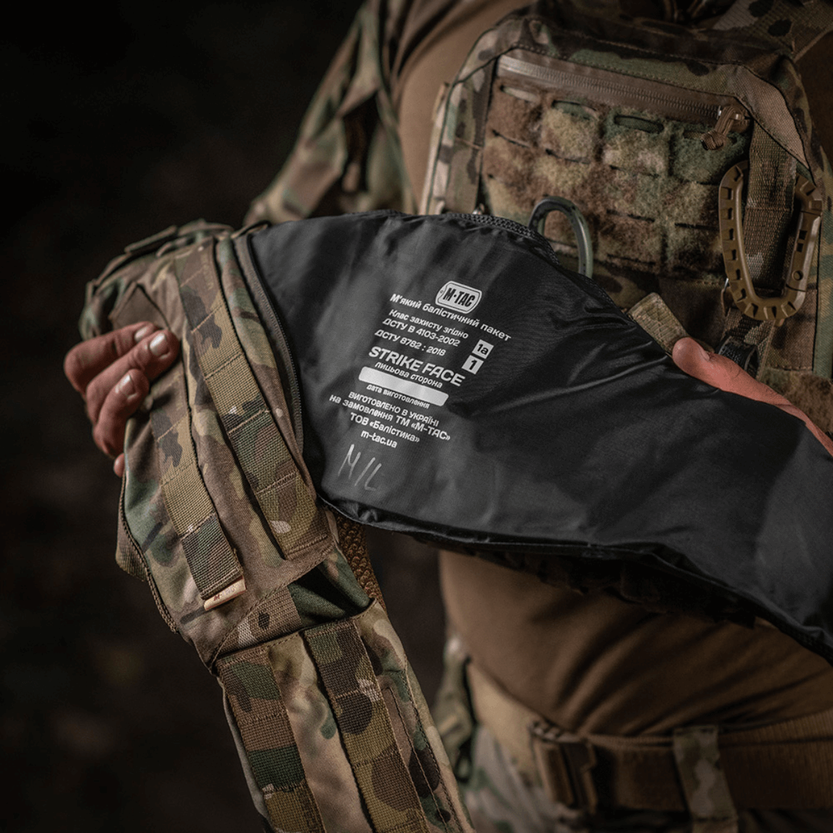 Henkilö pitää M-Tac War Belt ARMORia, jossa MOLLE-webbing ja kestävät materiaalit, sopii taktiseen käyttöön.