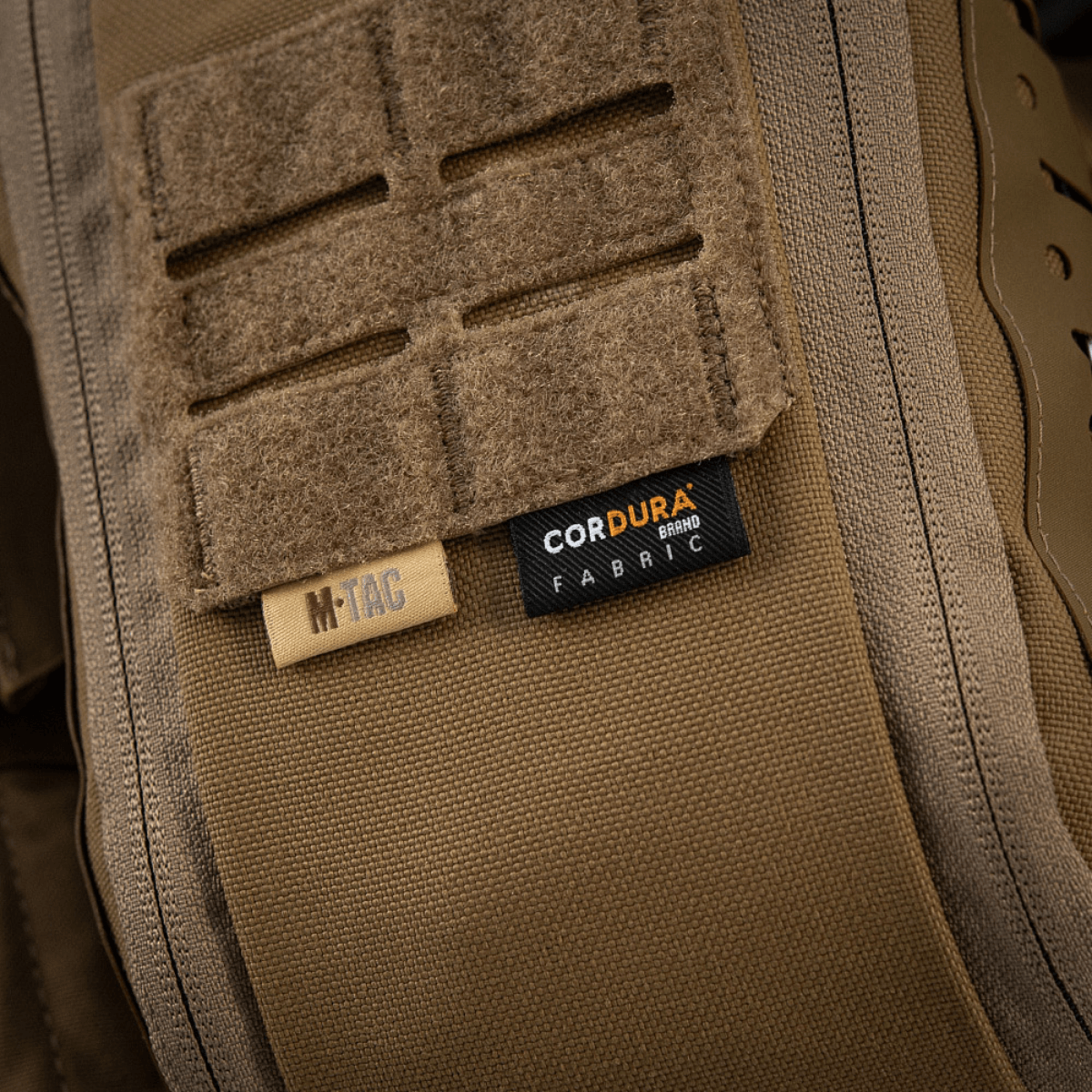 Lähikuva M-Tac Medical Pouch Elite Rip Off -pussin CORDURA®-kangasmerkistä ruskeassa taktikkavärissä.