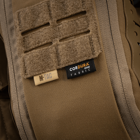 Lähikuva M-Tac Medical Pouch Elite Rip Off -pussin CORDURA®-kangasmerkistä ruskeassa taktikkavärissä.