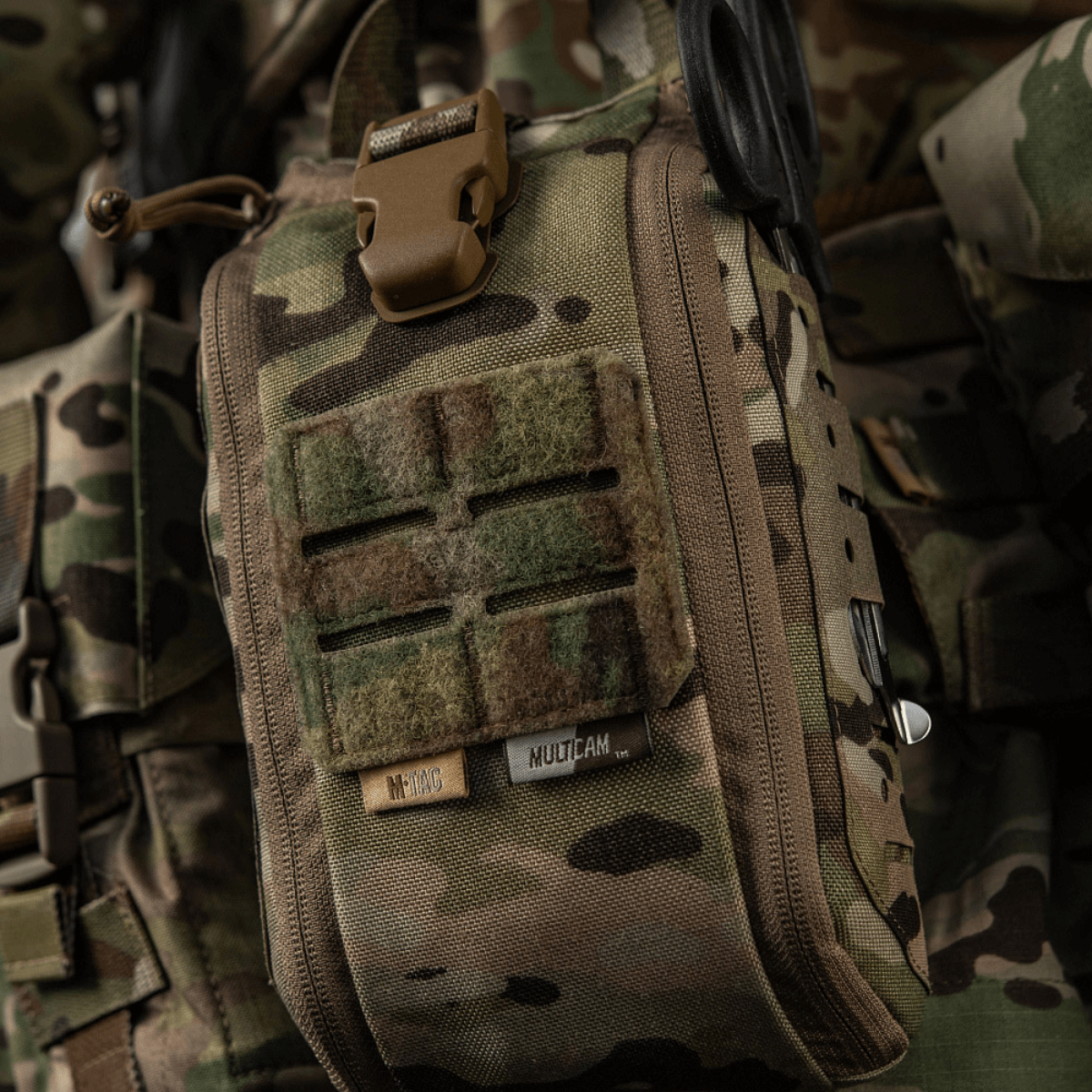 M-Tac Medical Pouch Elite Rip Off maastokuvioituna taktiseen käyttöön, kiinnitetty reppuun varusteineen kiireelliseen ensiapuun.