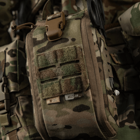M-Tac Medical Pouch Elite Rip Off maastokuvioituna taktiseen käyttöön, kiinnitetty reppuun varusteineen kiireelliseen ensiapuun.