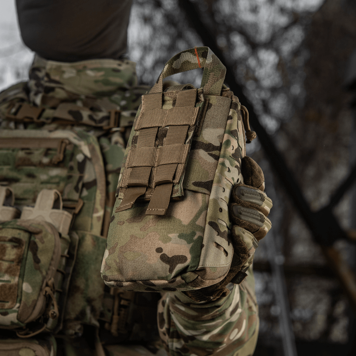 M-Tac Medical Pouch Elite Rip Off maastokuvioitu laukku sotilaan pitämänä taktisen varustuksen kanssa ulkona, sopii nopeaan lääkinnälliseen apuun