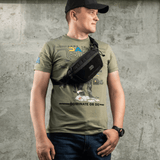 Mies käyttää M-Tac Tactical Waist Bag Gen.II Elite mustaa, sopii taktiseen ja arkikäyttöön, tehty kestävästä Cordura 1000D -materiaalista