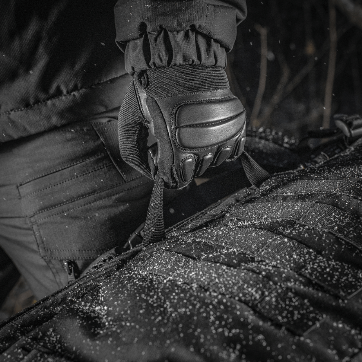 M-Tac Rygsæk Gen.II Elite Large, lähikuva Cordura-materiaalista, pidetty käsineellä lumisäällä.