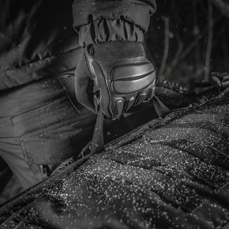 M-Tac Rygsæk Gen.II Elite Large, lähikuva Cordura-materiaalista, pidetty käsineellä lumisäällä.