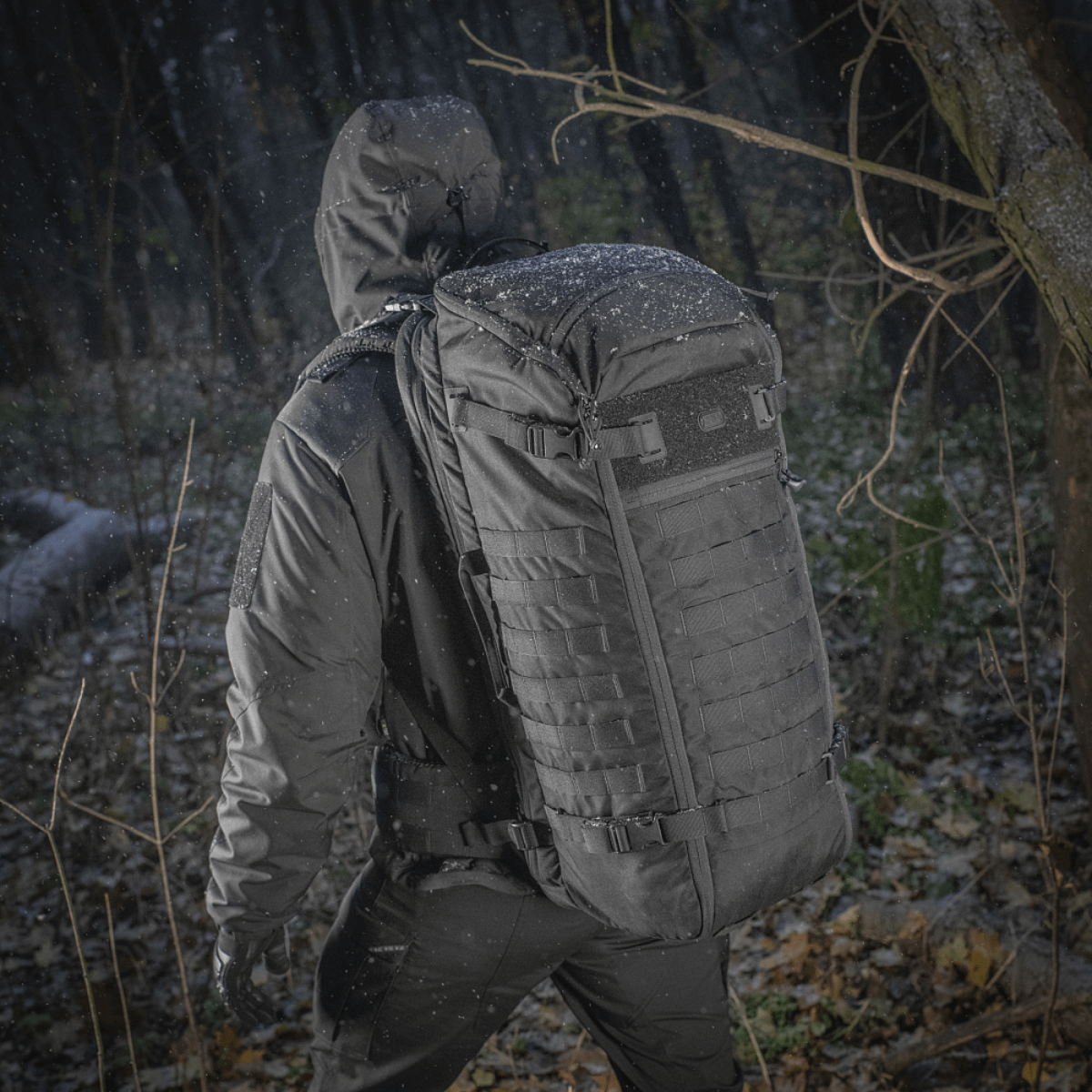 Henkilö kantaa M-Tac Rygsæk Gen.II Elite Largea metsäympäristössä.