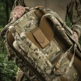 M-Tac Rygsæk Gen.II Elite Large, camo-malli, henkilön pitämä, näyttää ergonomisen muotoilun ja korkean kestävyyden.