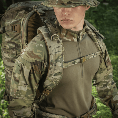 M-Tac Rygsæk Gen.II Elite Large on henkilöllä camouflase-uniformussa metsäympäristössä.