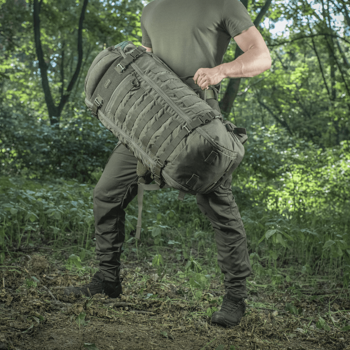 M-Tac Rygsæk Gen.II Elite Large, henkilön pitämä metsässä; ergonominen ja kestävä ulkoilureppu varusteiden kuljetukseen.