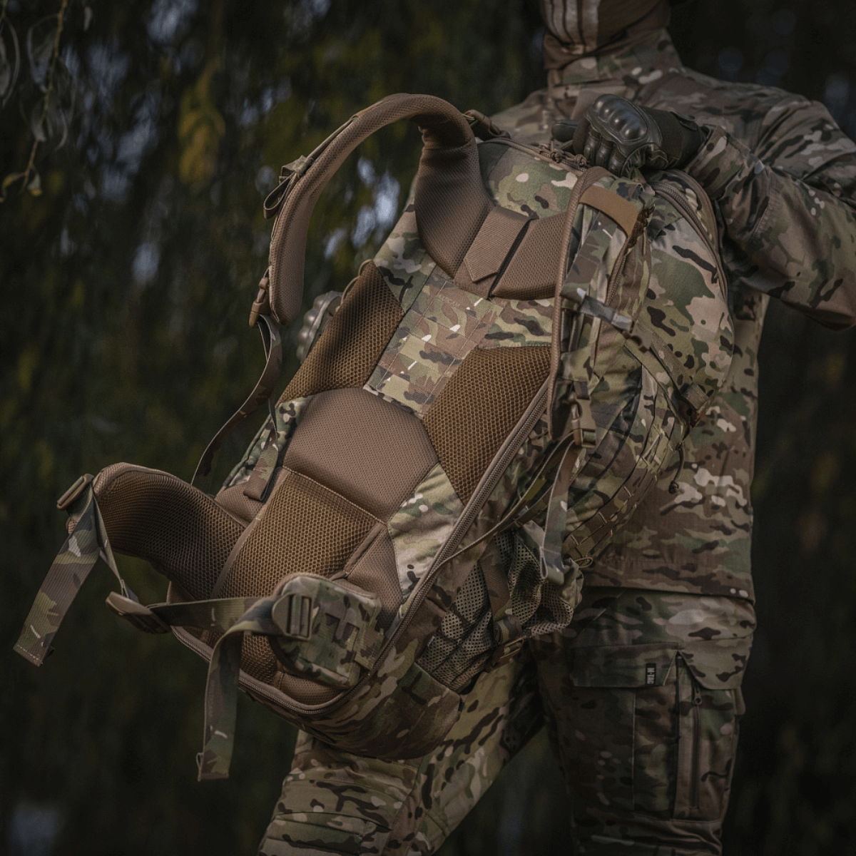 M-Tac Large Gen.IV Elite maastokuvio, ergonominen muotoilu, pidetään sotilaspukuisen henkilön toimesta luonnossa.