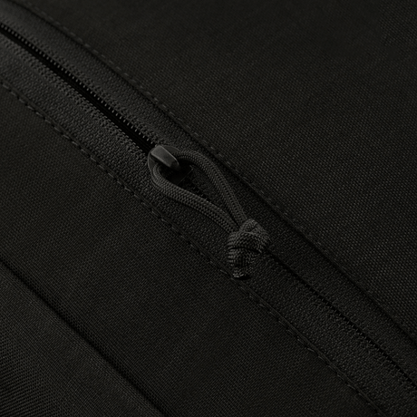 Lähikuva M-Tac Magnet XL Bag Elite -laukun vetoketjun yksityiskohdasta mustassa kankaassa.