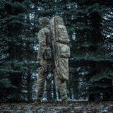 Henkilö metsässä M-Tac Gun Backpack Case 125 cm Gen.II Elite mukana, camo