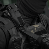 M-Tac Tourniquet Pouch Elastisk med MOLLE Gen.II kiinnitetty taktiikkaiseen liiviin, Cordura Squadron -materiaalista, varmistettu elastisella kiinnityksellä ja MOLLE-järjestelmällä.