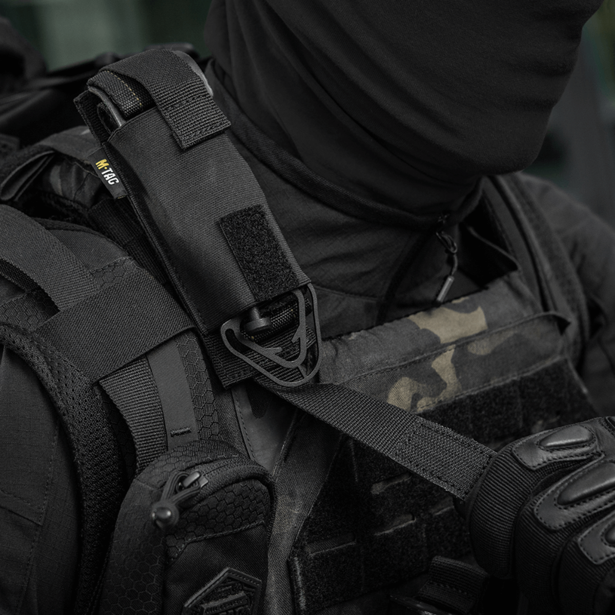 M-Tac Tourniquet Pouch Elastisk med MOLLE Gen.II kiinnitetty taktiikkaiseen liiviin, Cordura Squadron -materiaalista, varmistettu elastisella kiinnityksellä ja MOLLE-järjestelmällä.