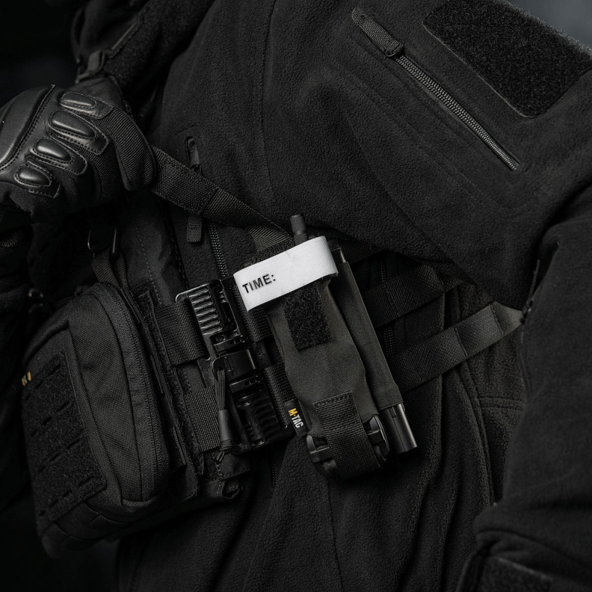 M-Tac Elastisk Tourniquet Pouch Molle Gen.III kannettuna taktisen varusteen osana, Cordura-materiaalia, suunniteltu nopeaan tourniquetin käsittelyyn.
