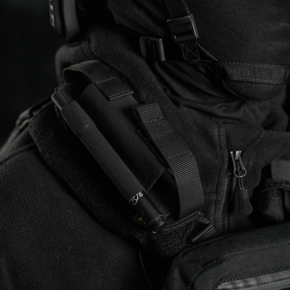 M-Tac Elastisk Tourniquet Pouch Molle Gen.III nopeaa pääsyä ja turvallista tourniquetin säilytystä varten, kiinnitettynä taktiseen varusteeseen.