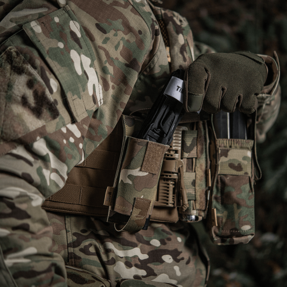 M-Tac Elastinen turnikekotelo Molle Gen.III kiinnitetty taktiseen liiviin camossa.