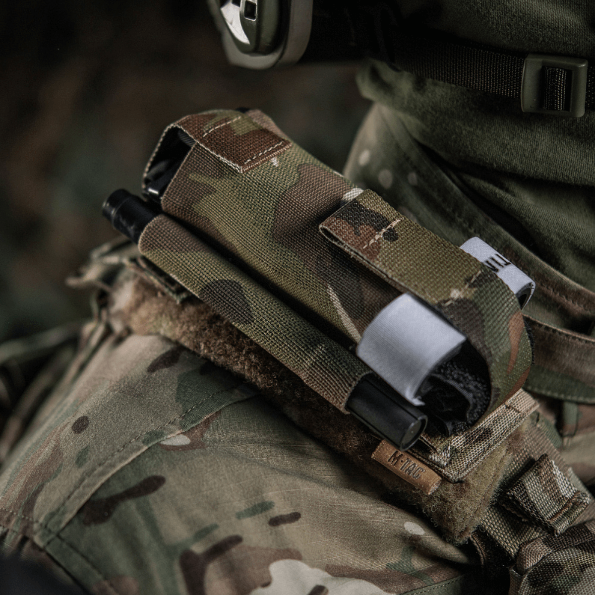 M-Tac Elastinen turnikekotelo Molle Gen.III kiinnitetty armeijan liiviin camossa, tarjoaa helpon pääsyn C-A-T tourniquettiin.