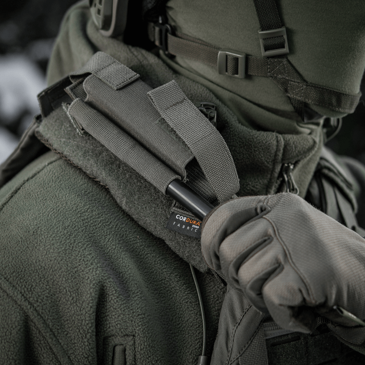 M-Tac Elastinen turnikekotelo Molle Gen.III käytössä, kiinnitetty taktisiin liiveihin, näyttää Cordura Squadron -materiaalin ja helpon pääsyn tourniquettiin.