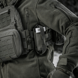 M-Tac Elastinen turnikekotelo Molle Gen.III kiinnitetty taktiseen takkiin henkilöllä kentällä.