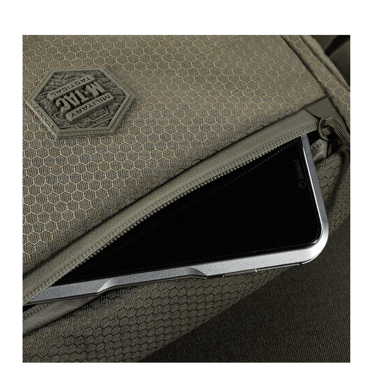 Yksityiskohta M-Tac Magnet XL Taske Elite Hexistä FidLock-lukitusjärjestelmällä ja Velcro-paneelilla, esillä älypuhelimen säilytys.