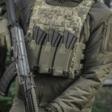 Henkilö pukeutuneena taktiseen liiviin, jossa M‑Tac Elastinen Triple Magazine Pouch Elite ja AK-lipat