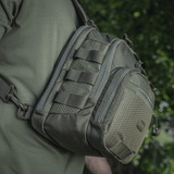 M‑Tac Cross Bag Elite Hex sling-laukku Cordura 500:sta, nähty olalla vihreässä ympäristössä, sopii päivittäiseen käyttöön ja taktisiin varusteisiin. 5 l.