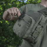 M-Tac Cross Bag Elite Hex -laukku käytössä, kestävä Cordura 500 -materiaali ja käytännölliset vetoketjut, täydellinen päivittäiseen ja taktiseen käyttöön.