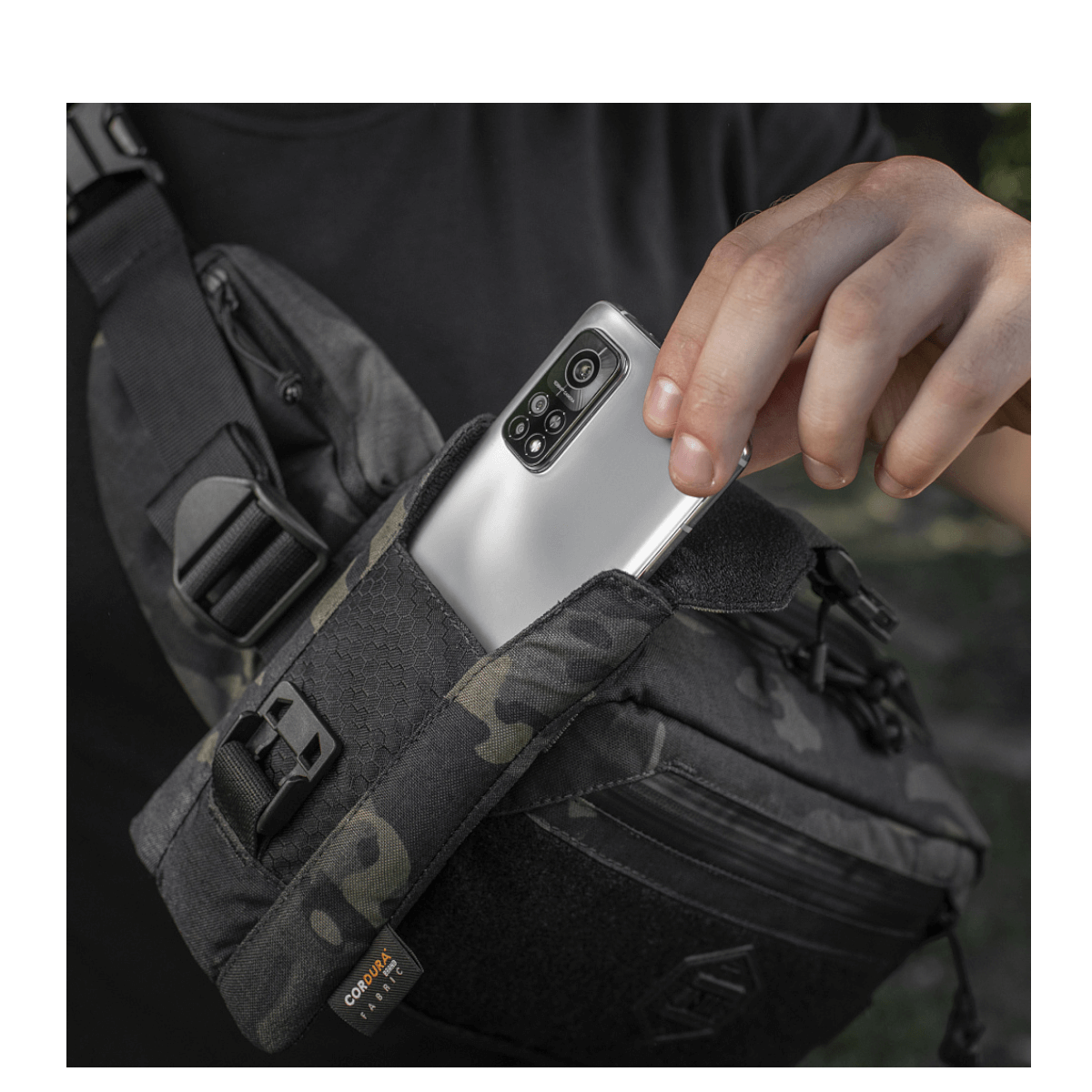 M-Tac Smartphone Lomme Elite Large Hex käytössä puhelimen turvalliseen säilytykseen kulutusta kestävästä CORDURA-materiaalista.