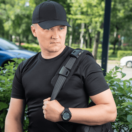 Mies kantaa reppua, jossa M‑Tac olkahihnan pehmike 50 mm Elite mukavuutta ja painonjakautumaa varten.