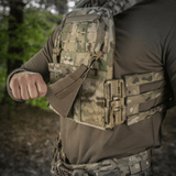 M‑Tac Front Panel Cuirass QRS käytössä sotilaan MOLLE-järjestelmässä, sopii kiinnitykseen taktisiin varusteisiin metsäympäristössä.