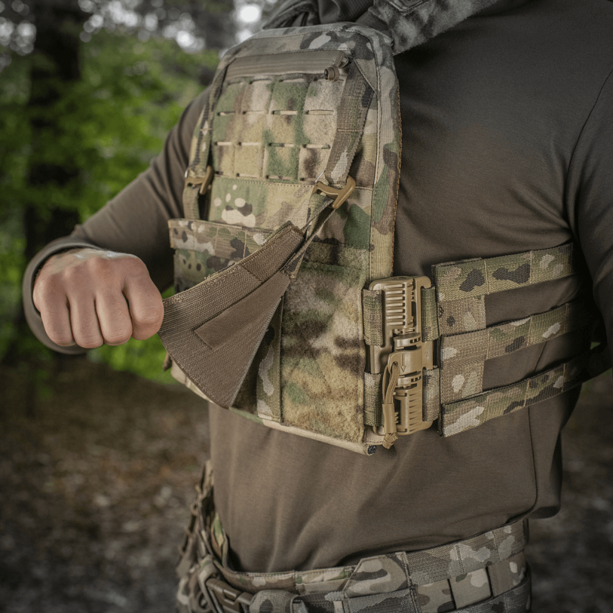 M‑Tac Front Panel Cuirass QRS käytössä sotilaan MOLLE-järjestelmässä, sopii kiinnitykseen taktisiin varusteisiin metsäympäristössä.