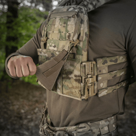 M‑Tac Front Panel Cuirass QRS käytössä sotilaan MOLLE-järjestelmässä, sopii kiinnitykseen taktisiin varusteisiin metsäympäristössä.