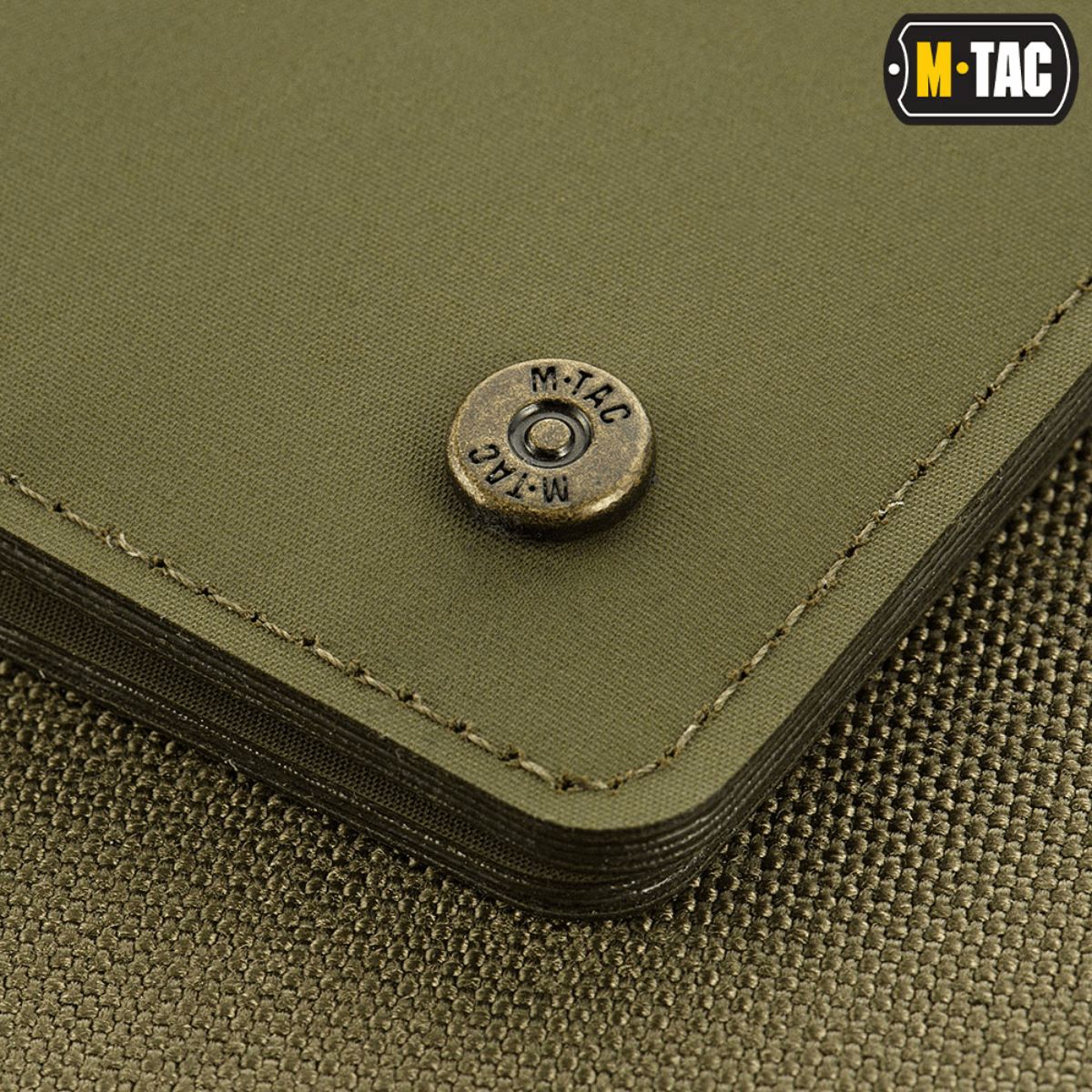 Lähikuva M-Tac Slim Elite Gen. II:stä brändatulla messinkiniitillä ja kompaktilla muotoilulla, valmistettu kulumiskestävästä polymeerikomposiitista.