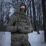 M-Tac taktinen käsilämmitin Elite käytössä lumisessa metsässä, pitää kädet lämpiminä Cordura-, fleece- ja G-Loft-eristyksellä.