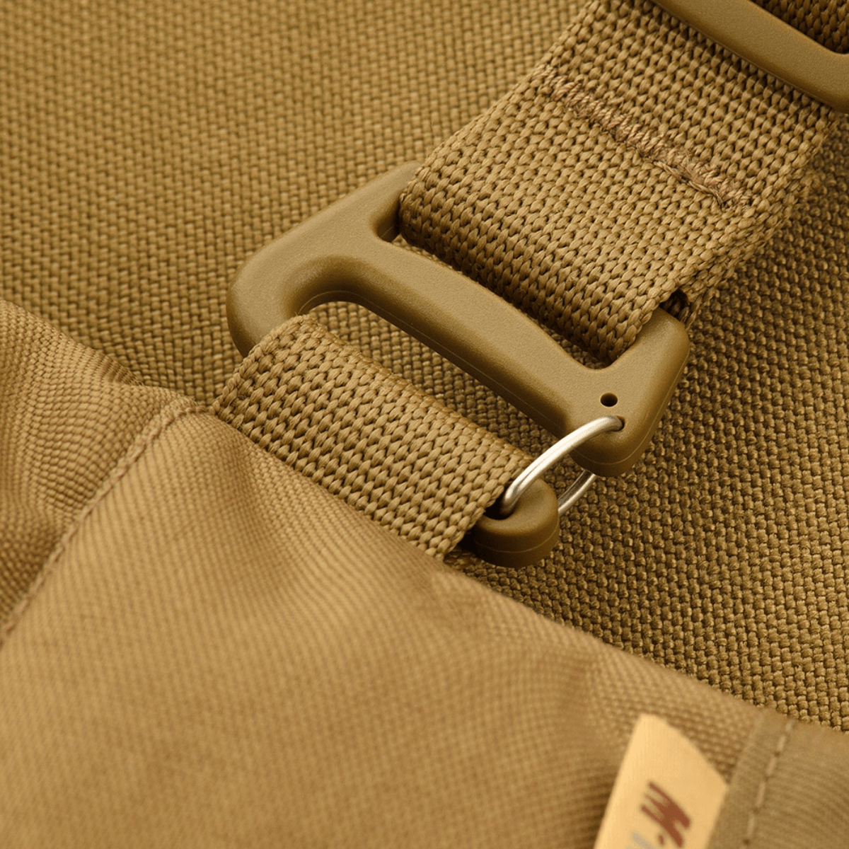 Lähikuva M-Tac taktinen käsilämmitin Elite, näyttää kestävän Cordura 500D -materiaalin ja soljen yksityiskohdan.